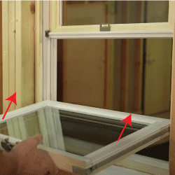 Close-up of a window with a bottom panel tilting inward, being closed by a hand with red arrows highlight the the upward motion of returning the window into the frame.