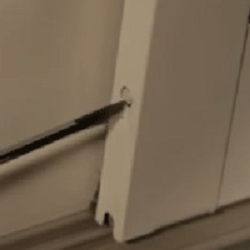 Close‑up of gliding patio door insect screen adjustment screw on bottom of screen frame.