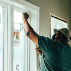 Person inside a home removing protective film from glass.